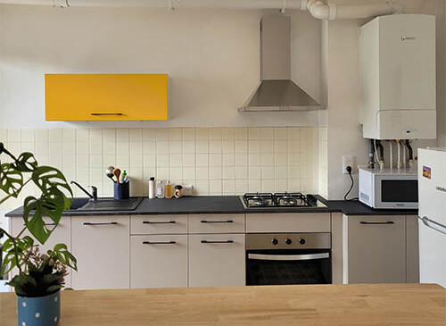 Cuisine en I avec ilot central avec façades en gris et plan de travail gris anthracite, design et tendance